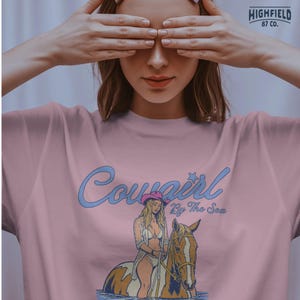 cowgirl with pink hat and horse in ocean water, coastal cowgirl graphic