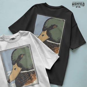 Waterfowl hunting style mallard duck head graphic in profile, showcasing the classic green head drake with dark chest and layered feather detail. The framed composition gives it a badge style appearance, making it perfect for hunting shirt design, sublimation prints, and mallard duck PNG digital download collections.