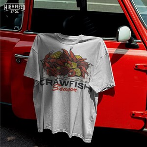 Crawfish boil summer shirt PNG displaying bright red crawfish and corn pieces with sliced lemons, arranged in a bold food illustration layout.