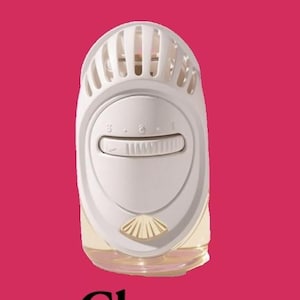 May include: A white plug-in air freshener device with a clear glass base containing liquid. The device features a horizontal adjustable dial with numbers 1 through 5 and a small shell-shaped accent at the bottom. The word Cherry is printed below.