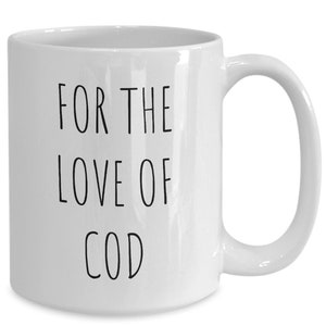 May include: White ceramic coffee mug with black text that reads "For the love of cod".