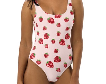 May include: A pink one-piece swimsuit with a pattern of red strawberries. The swimsuit has a scoop neck and thin straps.