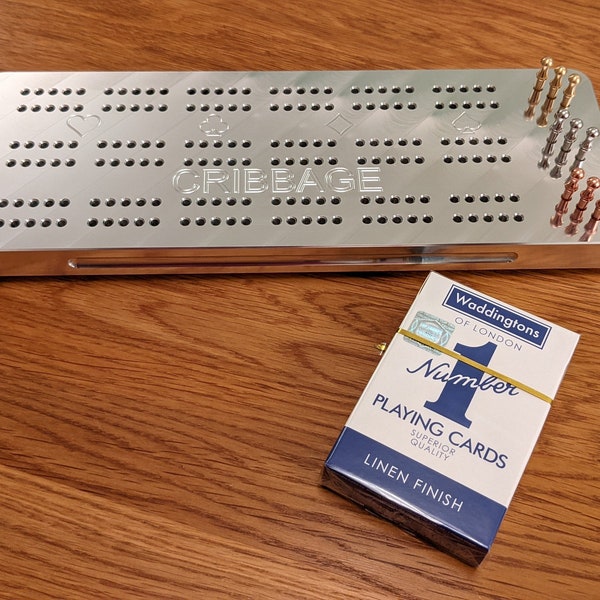 Solid metal cribbage board, nine metal pegs, and a deck of playing cards, to make this a 'ready-to-go' set to play the card game Cribbage