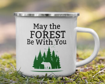 May include: White enamel camping mug with a black and green design. The mug has a silver rim and handle. The design features a bear standing in front of a line of green trees with the text "May the FOREST Be With You".