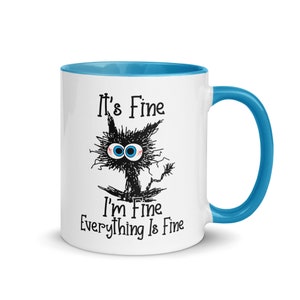 May include: White ceramic mug with a blue rim and handle. The mug features a black and white cartoon cat with the text "It's Fine I'm Fine Everything Is Fine."