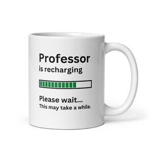 May include: White ceramic mug with black text that reads "Professor is recharging" with a green progress bar and the text "Please wait... This may take a while."