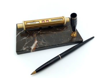 Perpetual desk calendar in black gold marble and its black plastic pen holder Gold Starry made in France from the 70s