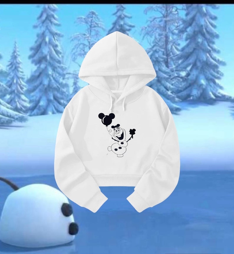 Op de afbeelding: Witte cropped hoodie met een zwart-witte afbeelding van Olaf uit Frozen die een ballon vasthoudt met Mickey Mouse oren.