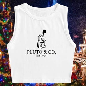 May include: White sleeveless crop top with a black and white illustration of Pluto, the Disney dog. The text "PLUTO & CO. Est. 1928" is printed below the illustration.