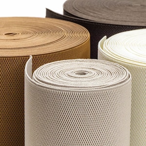 May include: Four rolls of elastic fabric in different colours: brown, beige, white, and grey. The fabric is woven with a textured pattern.