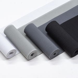 May include: Four rolls of elastic fabric in white, light grey, dark grey, and black. The fabric is rolled up and the ends are visible.