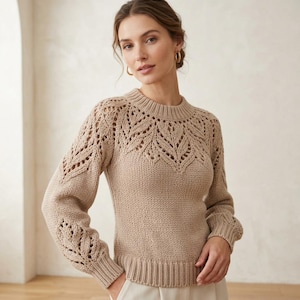 Peut inclure: Un pull beige à manches longues avec une encolure ronde et un motif ajouré décoratif sur la poitrine et les épaules. Le vêtement présente des poignets et un ourlet côtelés, avec une texture en maille unie sur le bas du torse et les manches.