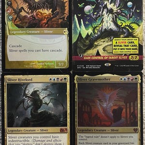 May include: Four Magic: The Gathering trading cards featuring Sliver creatures. The cards include "The First Sliver," "Sliver Overlord," "Sliver Hivelord," and "Sliver Gravemother." Each card has unique artwork and game text, with various mana costs and creature stats.