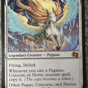 May include: A Magic: The Gathering card featuring "Thurid, Mare of Destiny." The card depicts a white Pegasus with flowing golden hair and blue wings. Text includes "Legendary Creature - Pegasus" and game mechanics. The card's power and toughness are 2/4.