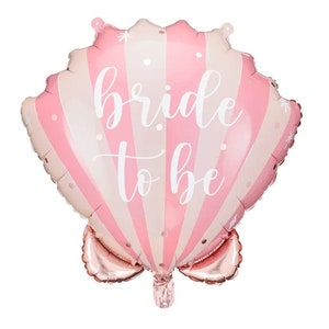Peut inclure: Ballon rose et blanc rayé en forme de coquillage. Le ballon porte l'inscription "bride to be" en écriture blanche sur le devant. Le ballon est conçu pour une fête de mariage ou un enterrement de vie de jeune fille.