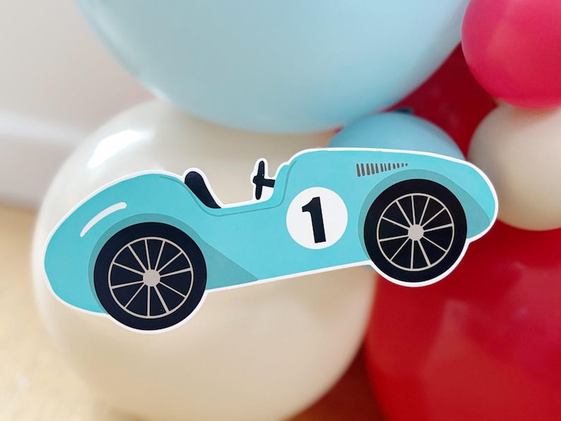 May include: A light blue race car sticker with black wheels and the number 1 on a white circle. The sticker is set against a backdrop of white, light blue, and red balloons, creating a festive atmosphere.