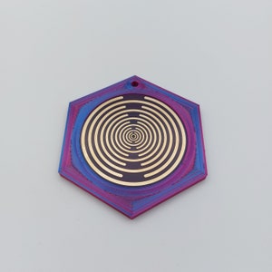 May include: A hexagonal pendant with a concentric circle design in gold on a dark purple background. The pendant has a blue and purple gradient finish.