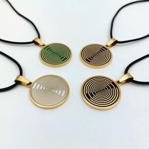 May include: Four gold necklaces with black cords and round pendants featuring a swirling, hypnotic pattern. The pendants are in green, purple, white, and black.
