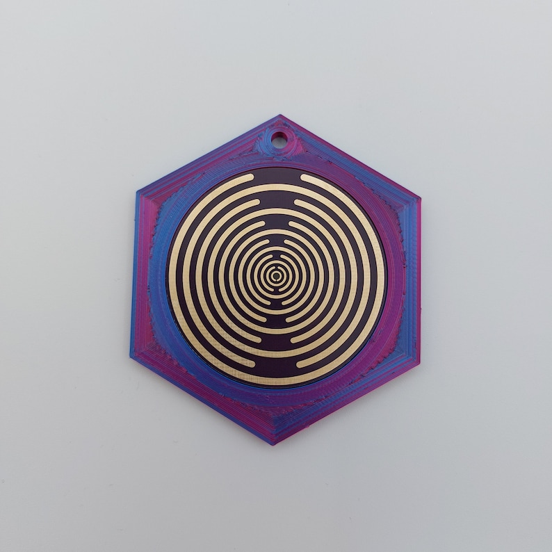 May include: A hexagonal pendant with a concentric circle design in gold on a purple and blue background.