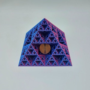 Può includere: Una struttura piramidale geometrica con un design frattale. La piramide è principalmente blu con accenti rosa e viola. Una spirale dorata è centrata sulla facciata anteriore. Il design generale è intricato e visivamente complesso.