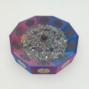 May include: Octagonal resin tray with a purple and blue swirl design. The tray is filled with silver metal shavings, purple crystals, and orange flower petals. A small purple crystal sits in the center of the tray.