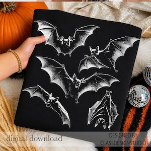 May include: A black fabric item featuring a white graphic print of five bats in various flight positions. The bats are depicted with detailed wings and faces. The text "digital download" and "DESIGNED BY CLASSDESIGNSTUDIO" is printed in the corners.