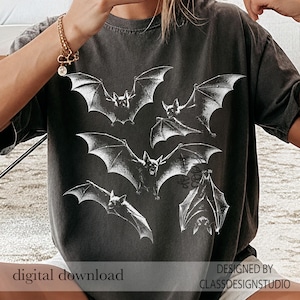 May include: A charcoal gray short-sleeve t-shirt featuring a white graphic print of five bats in various flight positions. The shirt has a crew neckline and a relaxed fit. The text digital download and DESIGNED BY CLASSDESIGNSTUDIO is visible.