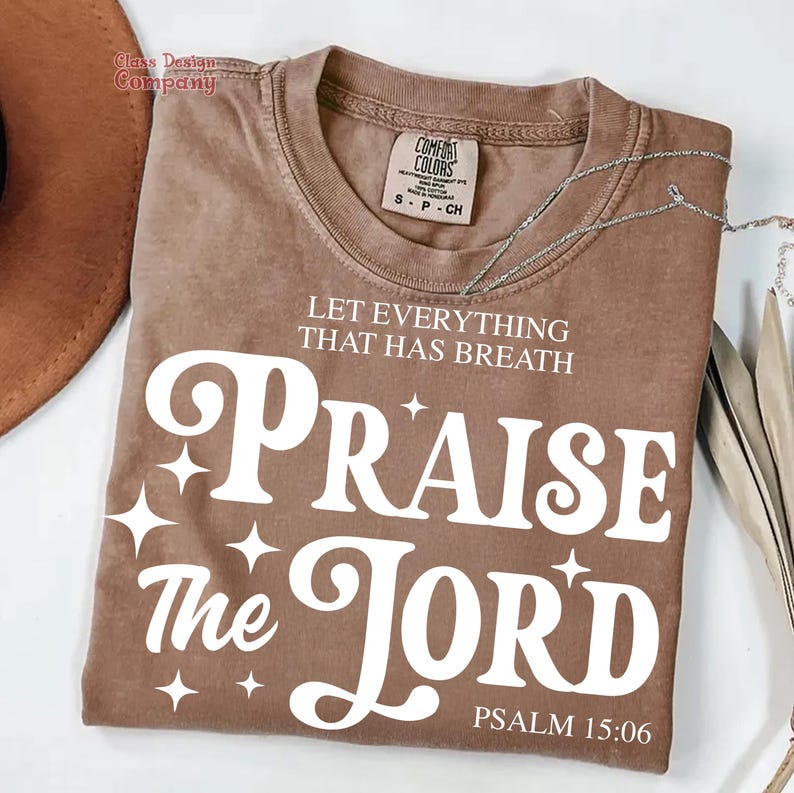 May include: A brown t-shirt with a white graphic that says "Let everything that has breath Praise the Lord" and "Psalm 15:06".
