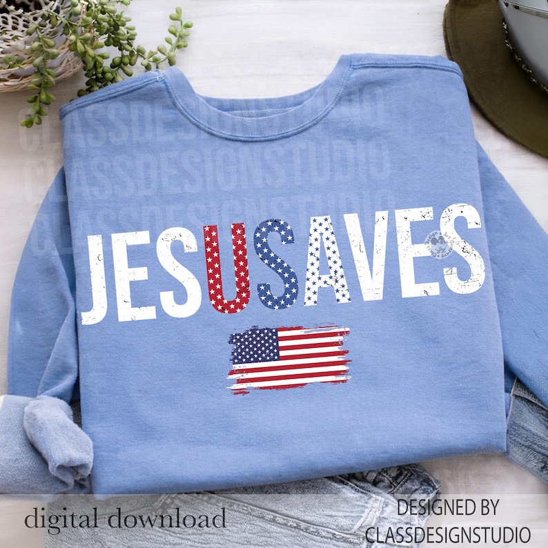May include: A light blue sweatshirt with the words "JESUS SAVES" in distressed white lettering. The letter "U" in "JESUS" is filled with red stars, and the letter "S" in "SAVES" is filled with blue stars. An American flag graphic is below.