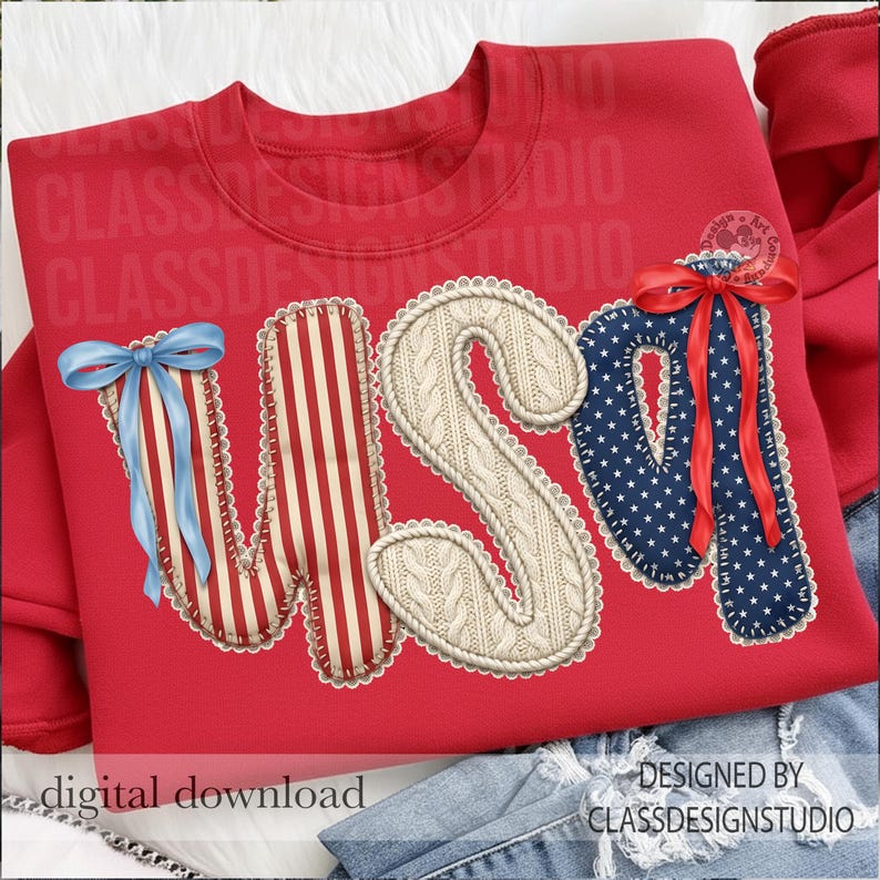 Puede incluir: Sudadera roja con la palabra "USA" en un dise&ntilde;o patri&oacute;tico. La "U" tiene un lazo azul, la "S" es un patr&oacute;n de punto de cable y la "A" es azul con estrellas blancas y un lazo rojo. La sudadera est&aacute; sobre un fondo de mezclilla.