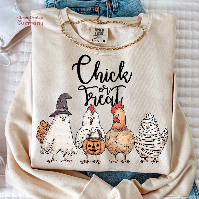 May include: Cream-colored sweatshirt with the text "Chick or Treat" and a graphic of four chickens in Halloween costumes. The chickens are wearing a witch hat, holding a pumpkin, and wrapped in bandages.