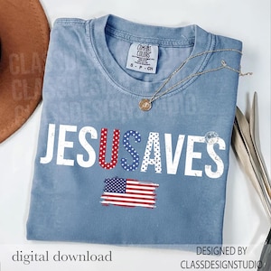 May include: A light blue t-shirt with the words "JESUS SAVES" in white, with the letters "U" and "S" in red and blue stars and stripes. An American flag graphic is below the text. A gold necklace is draped across the shirt.