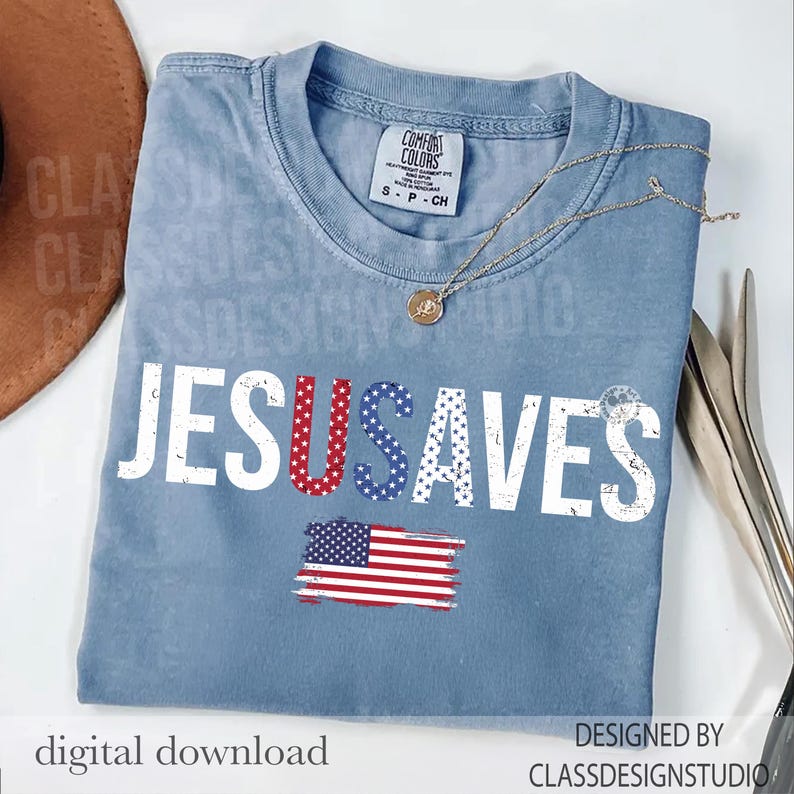 May include: A light blue t-shirt with the words "JESUS SAVES" in white, with the letters "U" and "S" in red and blue stars and stripes. An American flag graphic is below the text. A gold necklace is draped across the shirt.