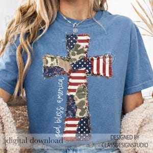 May include: A blue t-shirt featuring a cross design made of patches with American flag and camouflage patterns. The words "god bless america" are written vertically on the left side of the cross. The words "digital download" are at the bottom.