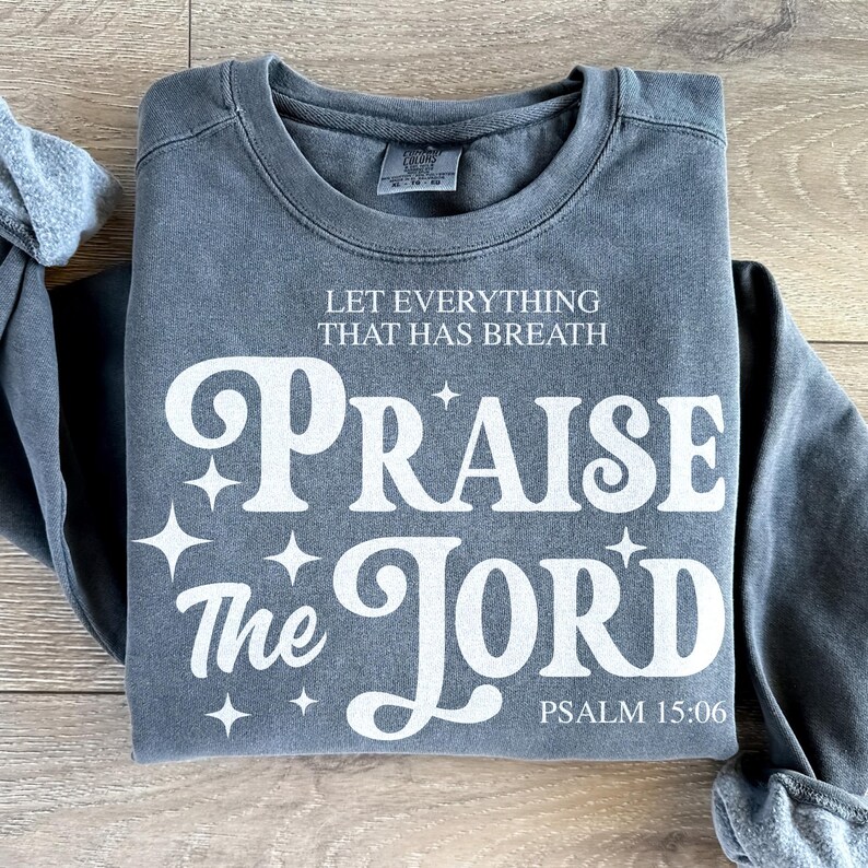 May include: A dark gray sweatshirt with a white graphic that says "Let everything that has breath Praise the Lord" and "Psalm 15:06".