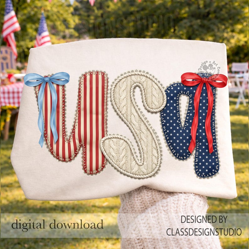 Puede incluir: Un bolso tote crema con las letras "USA" aplicadas. La "U" es a rayas rojas y blancas, la "S" es de punto de cable y la "A" es azul marino con estrellas blancas. Cada letra tiene un lazo decorativo.
