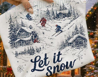 May include: A white fabric featuring a dark blue ink illustration of a snowy mountain landscape with skiers, pine trees, and cabins. The text Let it Snow is printed in a dark blue script font at the bottom of the design.