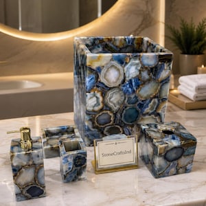 Puede incluir: Juego de accesorios de baño de piedra de ágata azul y blanca. El juego incluye un dispensador de jabón, un porta cepillos de dientes, una caja de pañuelos y un cesto de basura. Un letrero de metal dorado dice "StoneCraftsInd".