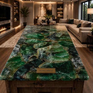 Può includere: Un grande tavolo rettangolare caratterizzato da una superficie in pietra preziosa verde lucidata con complesse venature naturali e profonde tonalità smeraldo. Una piccola targa rettangolare con il testo StoneCraftsInd è centrata sul tavolo.
