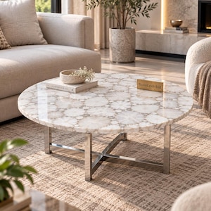 May include: A round coffee table featuring a white quartz geode slice tabletop with a polished finish. The table is supported by a silver-toned metal base with a cross-leg design. A small gold plaque with the text StoneCraftsInd sits on the surface.