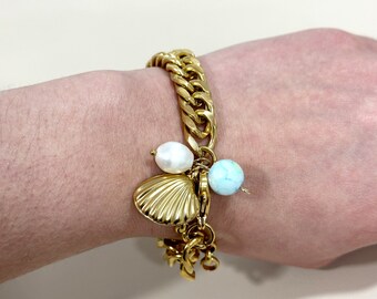 May include: A gold chain bracelet with a charm of a seashell, a pearl, and a turquoise-colored stone.