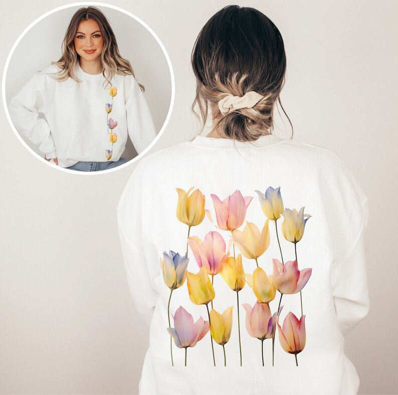 Peut inclure: Sweat-shirt blanc avec un motif aquarelle de tulipes rose pastel, jaunes et bleues au dos. Le devant du sweat-shirt est blanc uni.