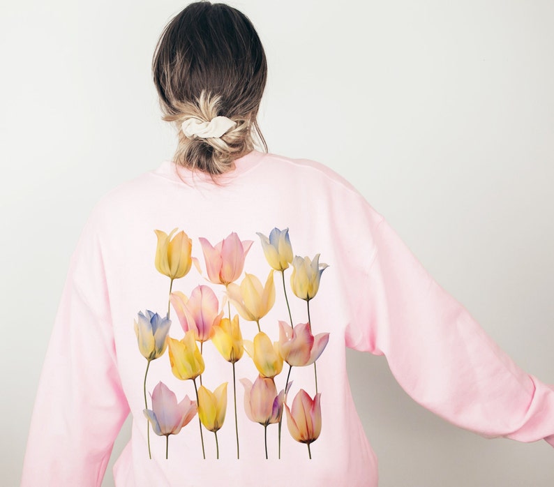 Peut inclure: Un sweat-shirt rose avec un motif aquarelle de tulipes jaunes, bleues et roses au dos.