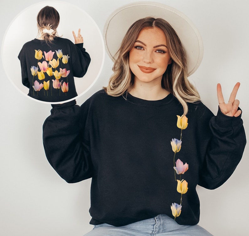 Peut inclure: Un sweat-shirt noir avec une rang&eacute;e verticale de tulipes color&eacute;es imprim&eacute;es sur le c&ocirc;t&eacute; droit. Le sweat-shirt a des manches longues et un col rond.