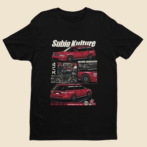 May include: Black t-shirt with a red Subaru Legacy wagon illustration. The design features the text "Subie Kulture" and "Second Generation".