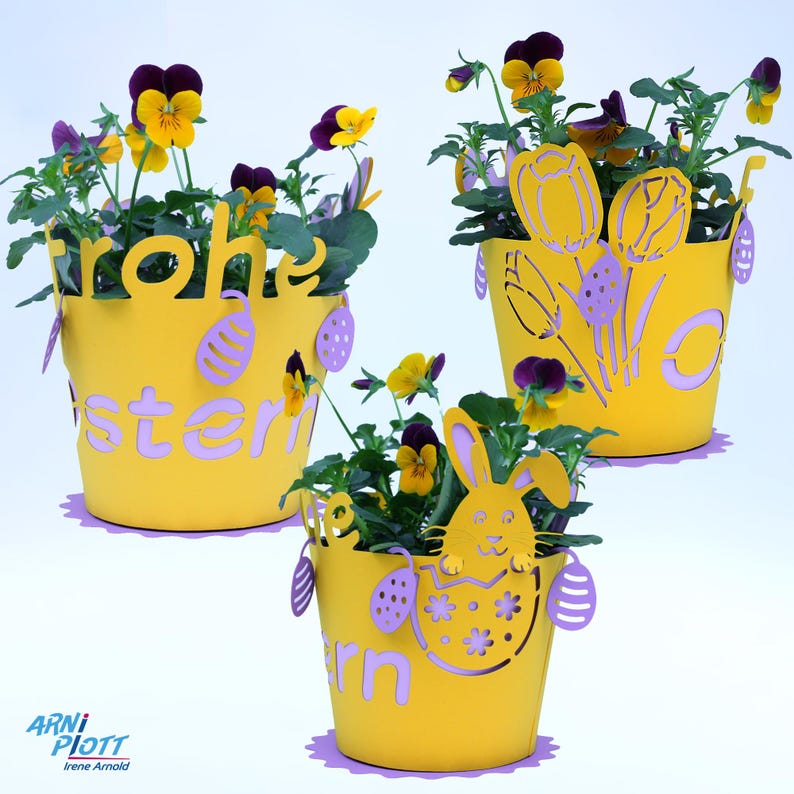 Op de afbeelding: Drie gele bloempotten met paarse en gele bloemen. De potten hebben verschillende paasontwerpen, waaronder een konijn, tulpen en de tekst "Frohe Ostern".