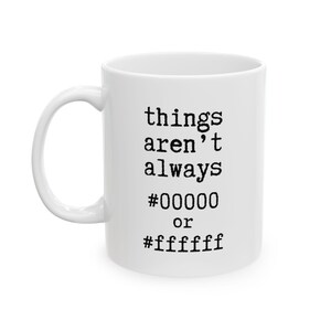Peut inclure: Tasse en céramique blanche avec une anse incurvée. La tasse porte un texte noir qui dit "things aren't always #00000 or #ffffff". La tasse est probablement utilisée pour les boissons chaudes.