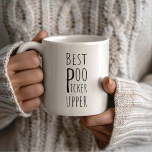 May include: White ceramic mug with black text that reads "Best Poo Picker Upper".
