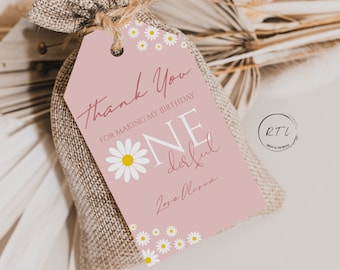 May include: Pink and white favor tag with a daisy design. The tag says "Thank you for making my birthday one delightful."