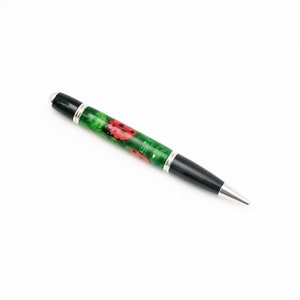 May include: A black and green pen with a silver trim and a design of ladybugs on the barrel.